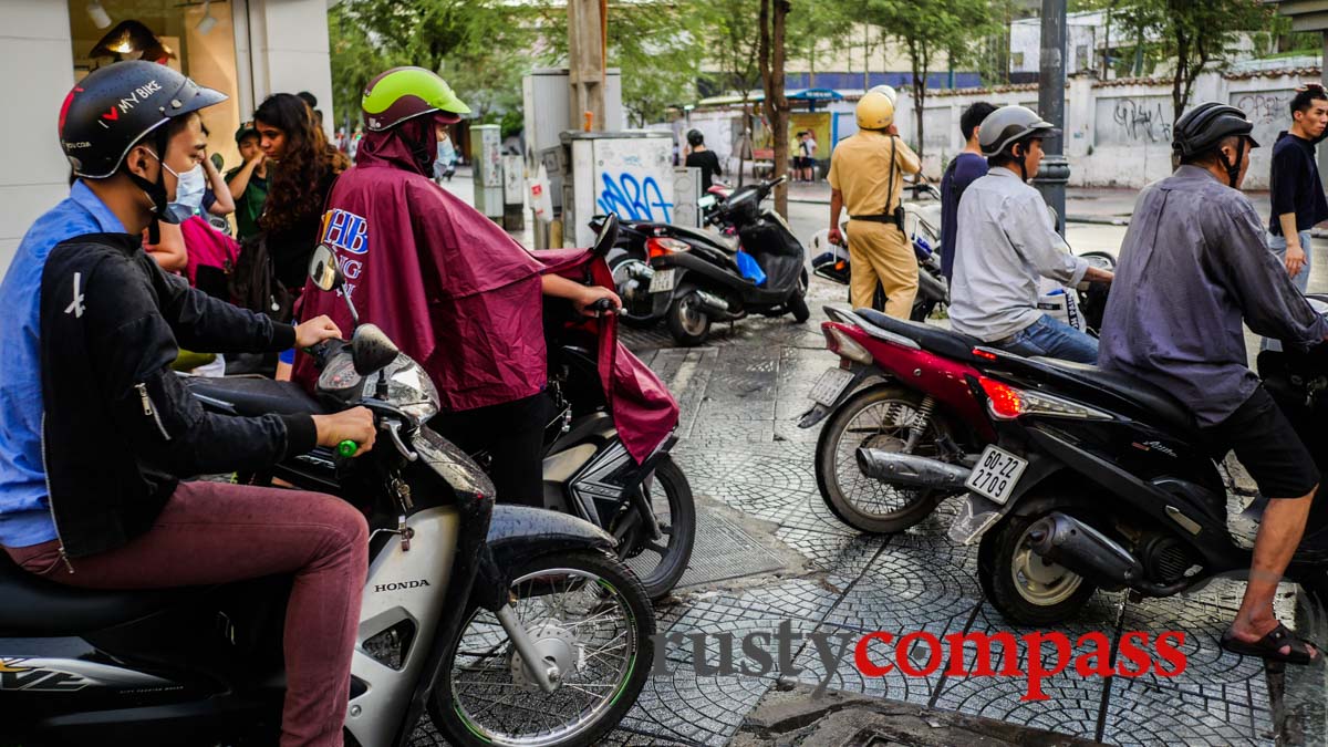 A policeman looks the other way. Saigon's pavements.